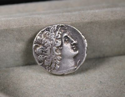 an image of a silver coin in a box with a pen in it