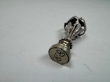 an image of a silver bottle stopper on a white surface