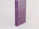 a purple book sitting on top of a white table next to a white wall