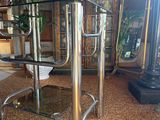 a glass table with a metal base in a room