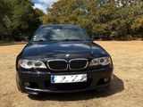 a picture of a black bmw car parked in a field