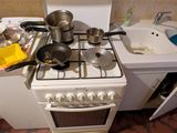 une petite cuisine équipée d'une cuisinière, d'un évier et d'un lave-vaisselle