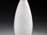 un vase blanc posé sur un socle noir