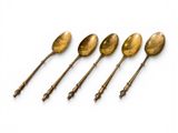 four spoons are lined up in a row on a white surface