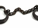 une paire de vieilles menottes en fer avec des chaînes, sur fond blanc