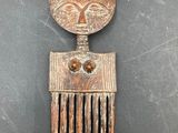 a close up of a metal comb with a face on it