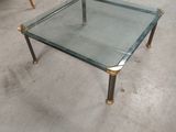a glass table with a metal frame on it in a room