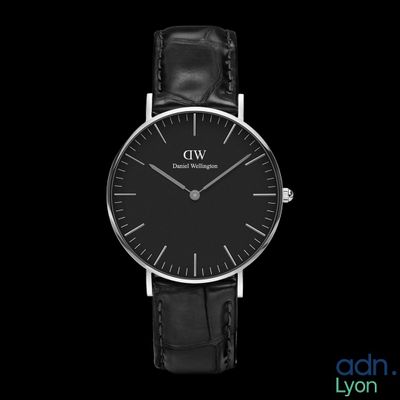 a close up of a black and silver watch on a black background