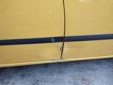 a yellow car that has a black stripe on the side of it