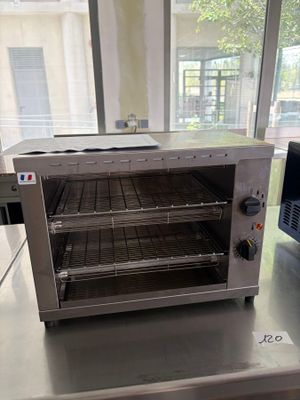 un four grille-pain posé sur un plan de travail devant une fenêtre