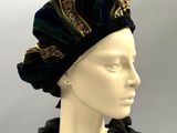 a close up of a mannequin head wearing a black dress and a turban