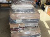 une grande pile de matelas posée sur une palette dans un entrepôt