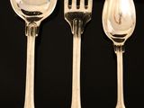 four spoons and a fork on a black table