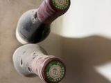 two bottles of wine sitting next to each other on a counter