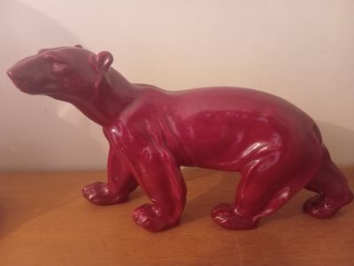 une figurine d'ours posée sur une table en bois