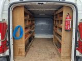 une camionnette blanche équipée d'étagères à l'arrière