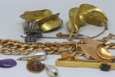 a lot of gold jewelry on a white surface
