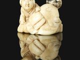 an old ivory figurine of a man and a child