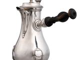 une image représentant une cafetière en argent posée sur une table