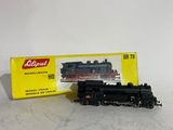 une locomotive noire et rouge posée à côté d'une boîte jaune