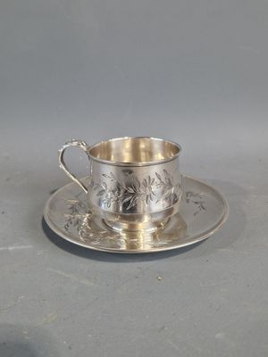 une tasse et une soucoupe en argent posées sur un plateau en argent