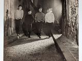 black and white photograph of a group of people walking down a street