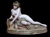 statue en marbre représentant une femme allongée sur un rocher, tenant un oiseau dans la main