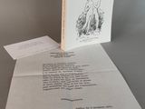 un livre ouvert posé sur une table à côté d'une feuille de papier