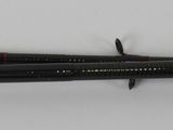 two black darts on a white surface with a red stripe