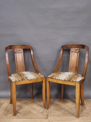 two wooden chairs with leopard print seats against a gray wall
