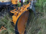 a yellow tractor that is sitting in the grass