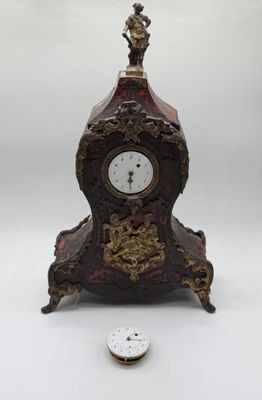 a small clock that is sitting next to a small coin