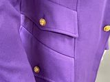 a close up of a purple jacket with gold buttons