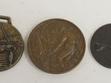 three bronze medals with a picture of a man and a woman