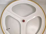 a white plate with a yellow rim and a red button