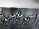 a close up of a metal bowl with a wave design
