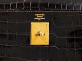 a close up of a black purse with a gold button