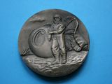 une image représentant une médaille d'argent sur laquelle figurent un homme et un chien