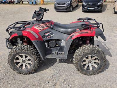 an image of a red four wheeler atv parked in a parking lot
