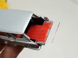a person holding a silver cell phone with a red button
