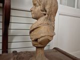 a bust of a young boy sitting on a table