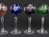 six different colored wine glasses are lined up in a row