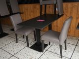 a table and chairs in a restaurant with a sign on it