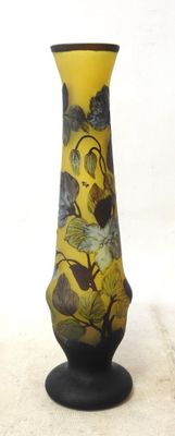 a yellow vase with birds on it sitting on a table