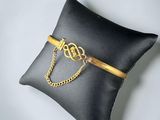 a black pillow with a gold chain on it