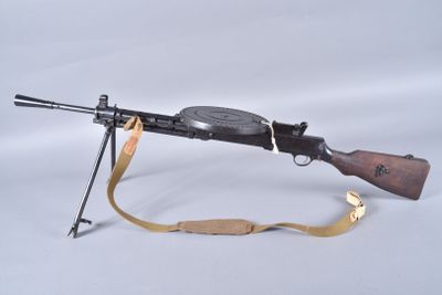 an old machine gun with a sling on a white background