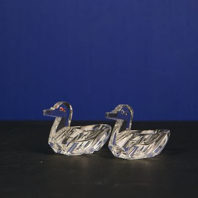 Paire de salerons en verre en forme de canards stylisés.