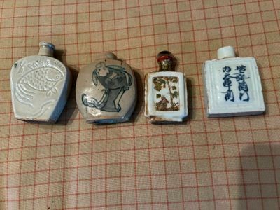 trois petites bouteilles portant des inscriptions en caractères asiatiques, posées sur une table