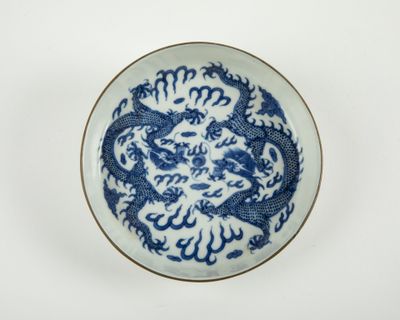 assiette bleue et blanche ornée d'un dragon sur fond blanc
