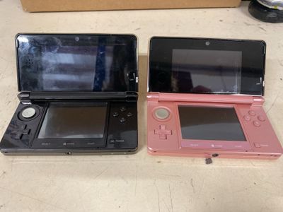 deux Nintendo 3DS posées l'une à côté de l'autre sur une table